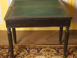a small table with a green top on a rug