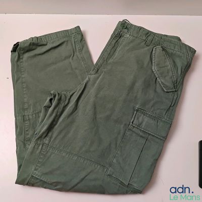 a pair of green pants sitting on a table next to a cell phone