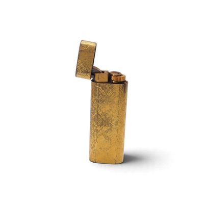 un briquet doré posé sur une surface blanche