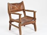 an old wooden chair with a brown leather seat on a white background