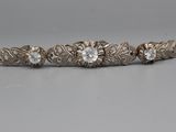 a close up of three antique diamond bracelets on a table