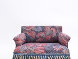 an upholstered chair with a floral print and fringes on it
