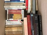 une boîte remplie de livres empilés les uns sur les autres
