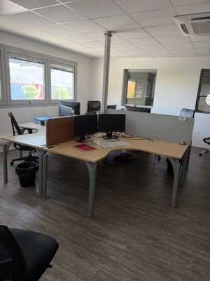 a desk with two computers and a chair in an office