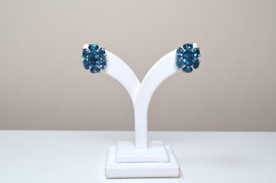 pair of blue crystal earrings on a white stand on a white table