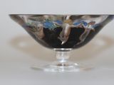 a glass bowl with a painting on it on a table