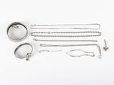 an assortment of silver jewelry including a ring, bracelet, and ring