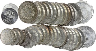 a pile of coins and a coin on a white background