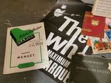 a pile of music books on the floor next to a refrigerator