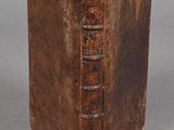 un vieux livre à la couverture brune posé sur une table