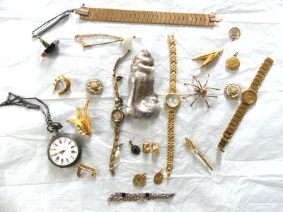 beaucoup de bijoux en or posés sur un drap blanc