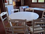une table et des chaises blanches dans une cuisine, avec un jacuzzi en arrière-plan