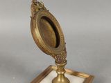 un petit miroir posé sur un socle en marbre