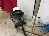 an image of a vacuum and a hose next to a red door