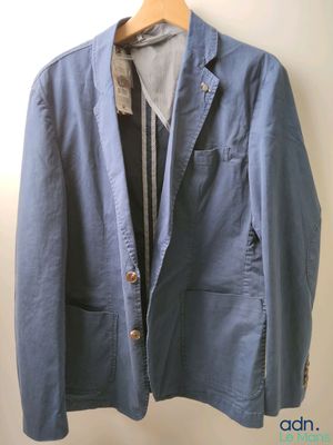 une photo d'une veste bleue suspendue à un cintre accroché au mur