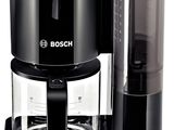 La cafetière est noire et est équipée d'un récipient en verre.