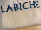 a white shirt with blue letters on it sitting on a wooden floor