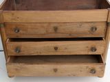 a small wooden box with three drawers on it
