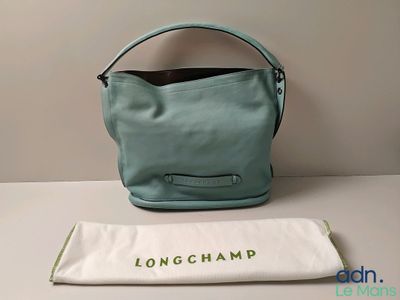 the longchamp bag is sitting on a table next to a towel