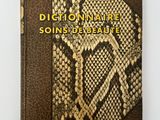 un livre dont la couverture est en peau de serpent et sur laquelle figurent des lettres dorées