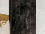 a black book that is laying on a white sheet