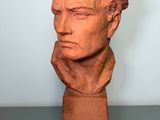 a close up of a clay bust of a man on a table