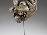 a sculpture of a head on a stand with a gray background