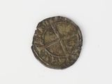 an old coin with a cross on it on a white surface