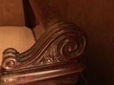 a wooden bench with a carved headboard and foot rest