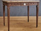 a small table with a marble top on a wooden floor