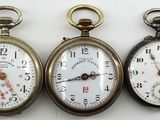 trois types différents de montres de poche posées sur une surface blanche