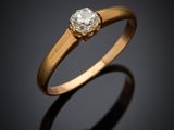 a gold ring with a diamond on a black background