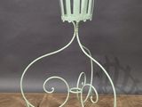 wrought iron candle holder on wooden floor with grey background