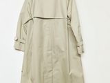 the back of a beige trench coat hanging on a white wall