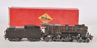 un petit train en jouet posé à côté d'une boîte rouge