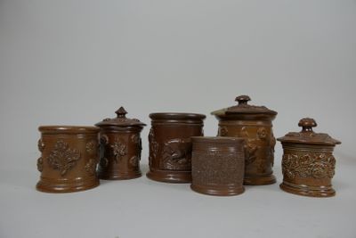 cinq vases marron posés sur une table, sur fond blanc