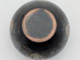 an image of a black vase on a white surface