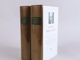 two books sitting on top of each other on a white surface