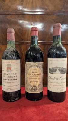 three bottles of wine are lined up on a red cloth