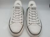des chaussures Converse avec des lacets blancs et un logo vert sur le côté