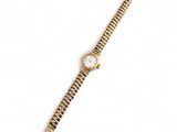 une montre-bracelet en or avec un cadran blanc et un bracelet en or
