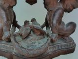 a wooden table with a statue of a boy and a bird on it