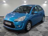 une voiture bleue est garée dans une pièce au sol à carreaux