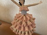 une figurine représentant une femme en robe, posée sur une table