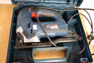 a blue tool box with a drill and other tools in it