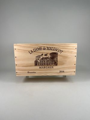 La caisse en bois, posée sur une table, contient une bouteille de vin.