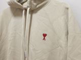 beige hoodie with a red heart on the chest and a red heart on the chest