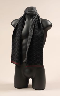 une écharpe noire et rouge sur une tête de mannequin
