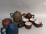 de nombreuses tasses et théières posées sur une table