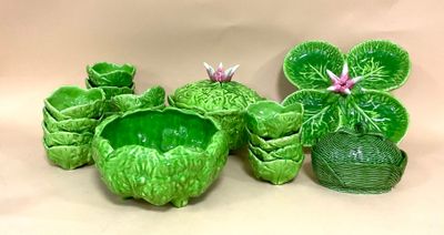 trois pots en céramique verts, ornés de fleurs et de feuilles, posés sur une table